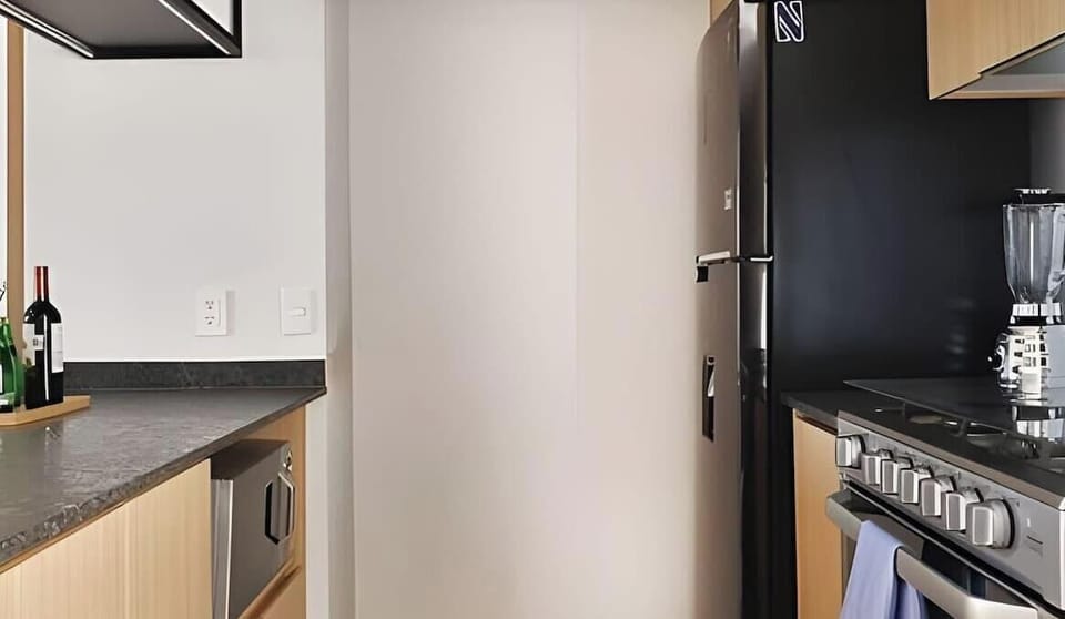 Modern kitchen corner w/ fridge, stove & streamlined cabinetry