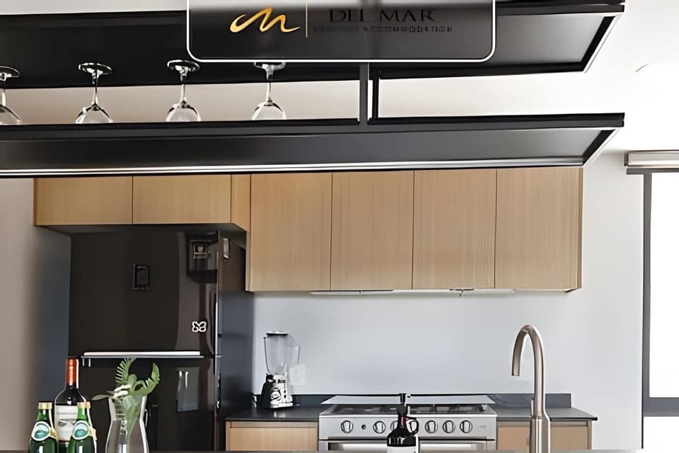 Contemporary kitchen w/ vent hood, cooktop & clean wood cabinetry