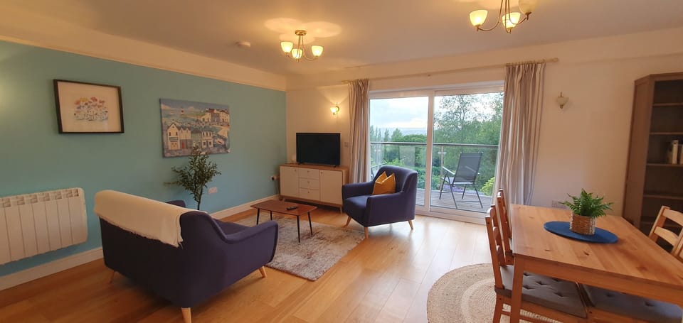 Living and dining area with sliding doors to deck and private garden.