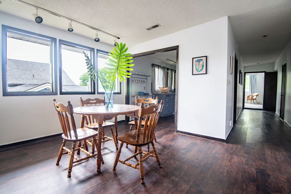 Bright dining area with wood furnishings – Natural light floods this comfortable and classic dining setup.