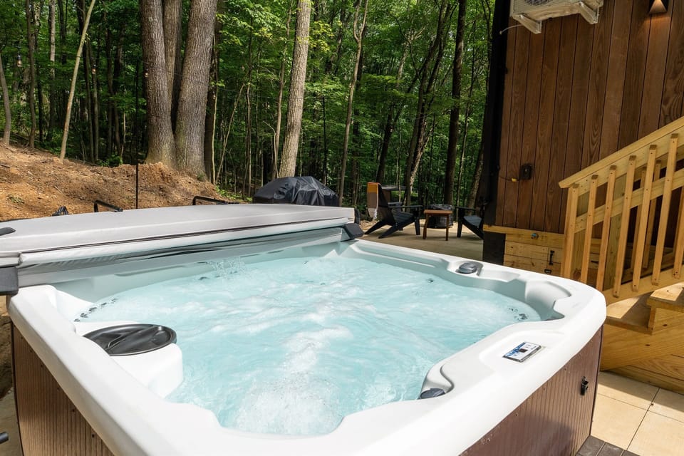 Personal hot tub at Muir — nestled against a natural rock formation, fully exposed, striped towels provided