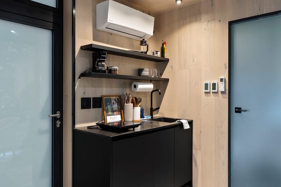 Kitchenette close-up at Thoreau — coffee maker, counter space, apartment-size fridge, pantry basics stocked on arrival