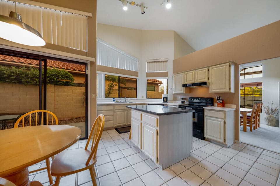 Well-equipped kitchen with island, cozy eating area, and access to the home`s lovely side patio
