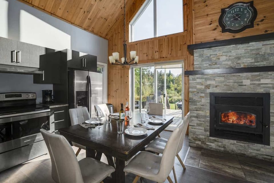 Bright dining area with a welcoming fireplace and large windows offering beautiful views.