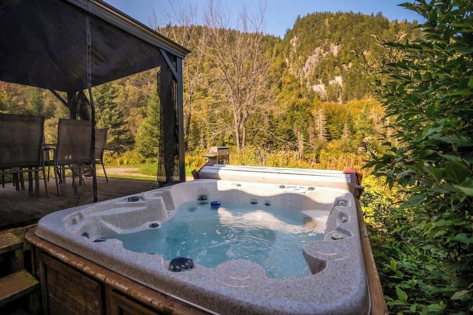 Hot tub with scenic forest and mountain views for ultimate relaxation.
