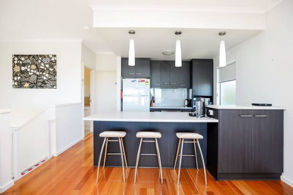 Cook with ease in the fully equipped kitchen featuring an oven, cooktop, microwave, dishwasher and full-sized fridge, with everything set up for shared meals and easy entertaining.