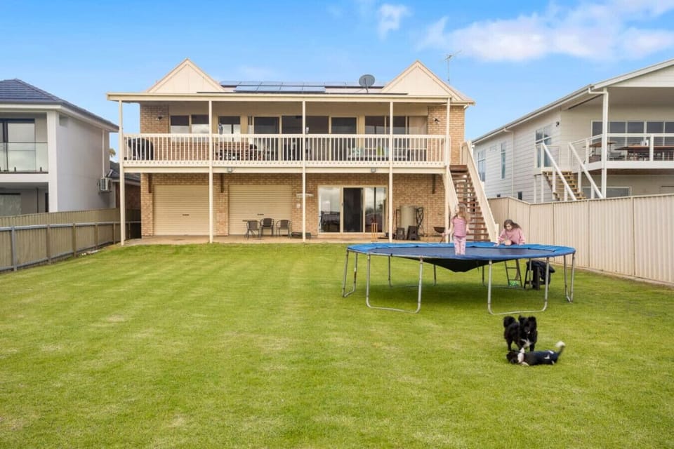 The grassy backyard offers ample space for pets and kids to play.