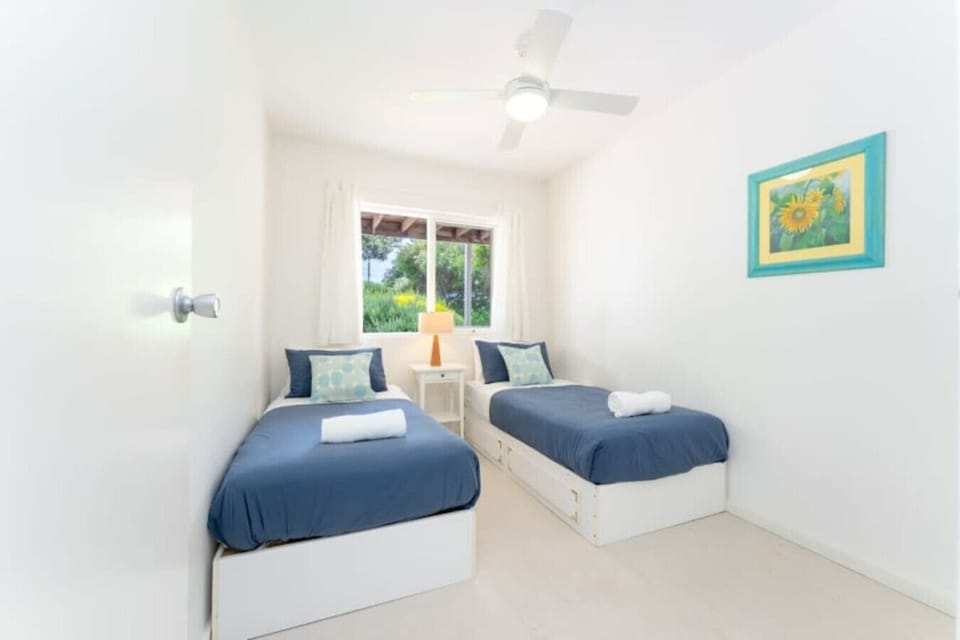 The third bedroom offers twin beds and a quiet garden outlook—ideal for friends or kids to recharge after beach adventures.