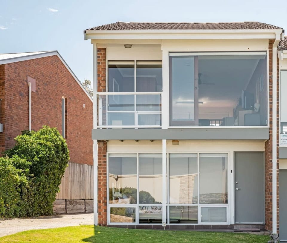 An original 1980s brick townhouse perched above the shoreline, offering front-row views of Knights Beach.