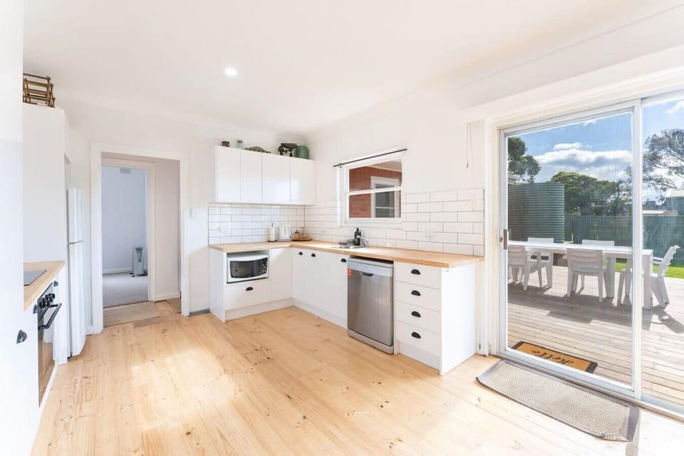 The kitchen offers white cabinetry, timber bench tops and premium appliances.