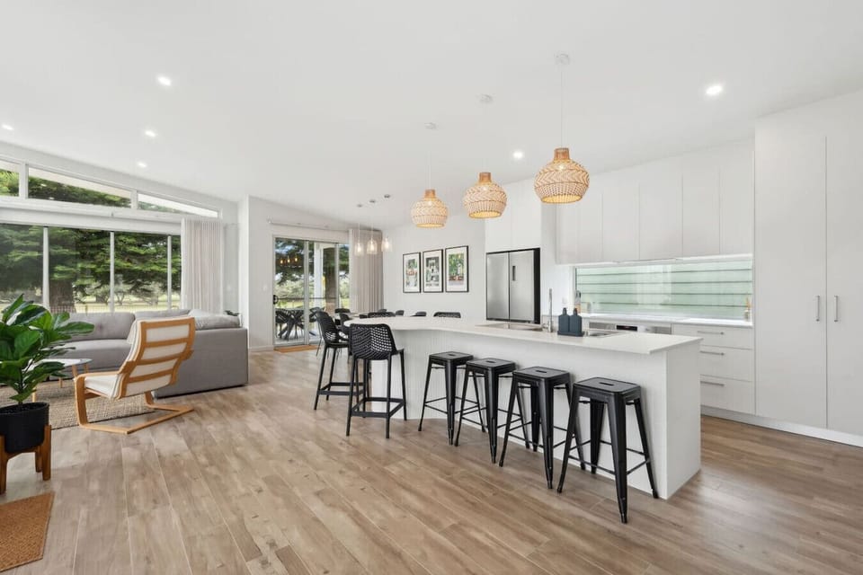 An island bench anchors the open-plan layout, linking kitchen and living areas.