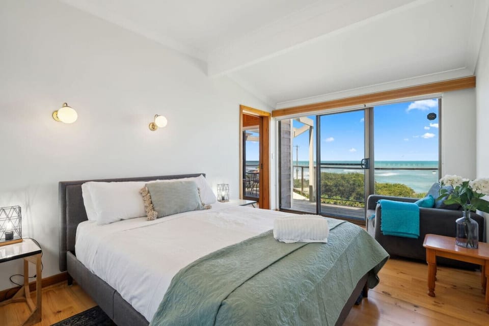 Wake to uninterrupted ocean views from the primary bedroom, where a queen bed and gentle light shape slow mornings.