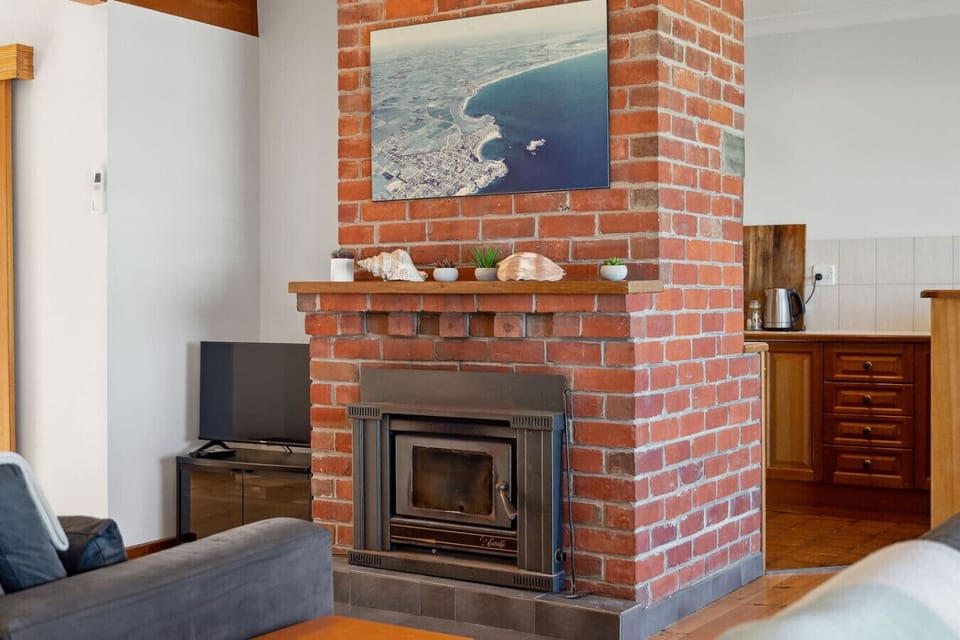 An exposed brick fireplace brings warmth and character.