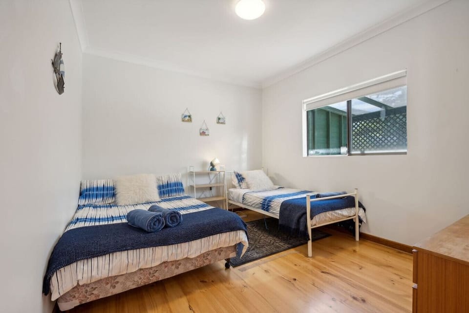 Wind down in the second bedroom, offering a queen bed and single bed in a calm setting.