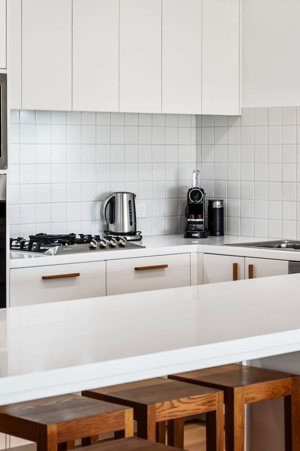 A closer look at the bench with kettle, Nespresso machine, and gas cooktop ready for use.