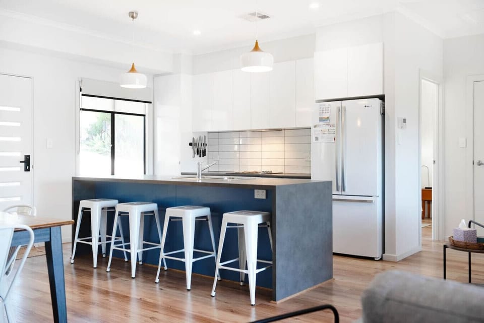 Start the day at the island bench, where pendant lighting and bar seating make breakfast feel effortless.