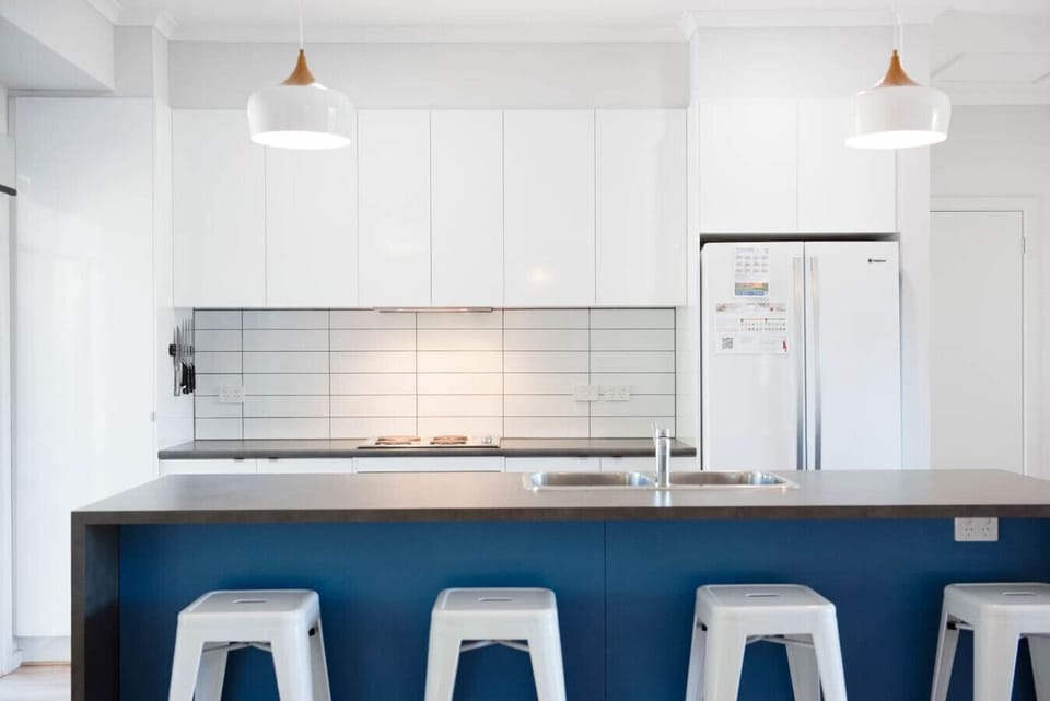 Cook with ease in a bright kitchen featuring sleek cabinetry, modern appliances, and a tiled splashback for a clean, contemporary feel.