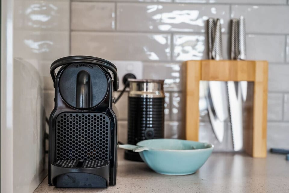 Coffee station setup with a Nespresso machine and milk frother..