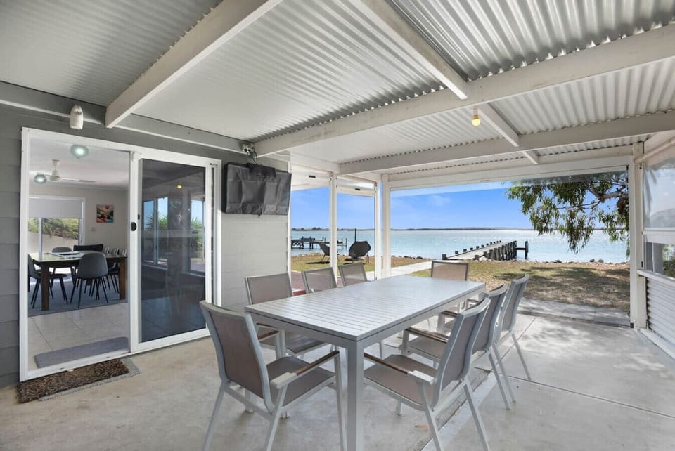 Enjoy long, lazy lunches under the covered patio, where water views and open air create the perfect outdoor table.