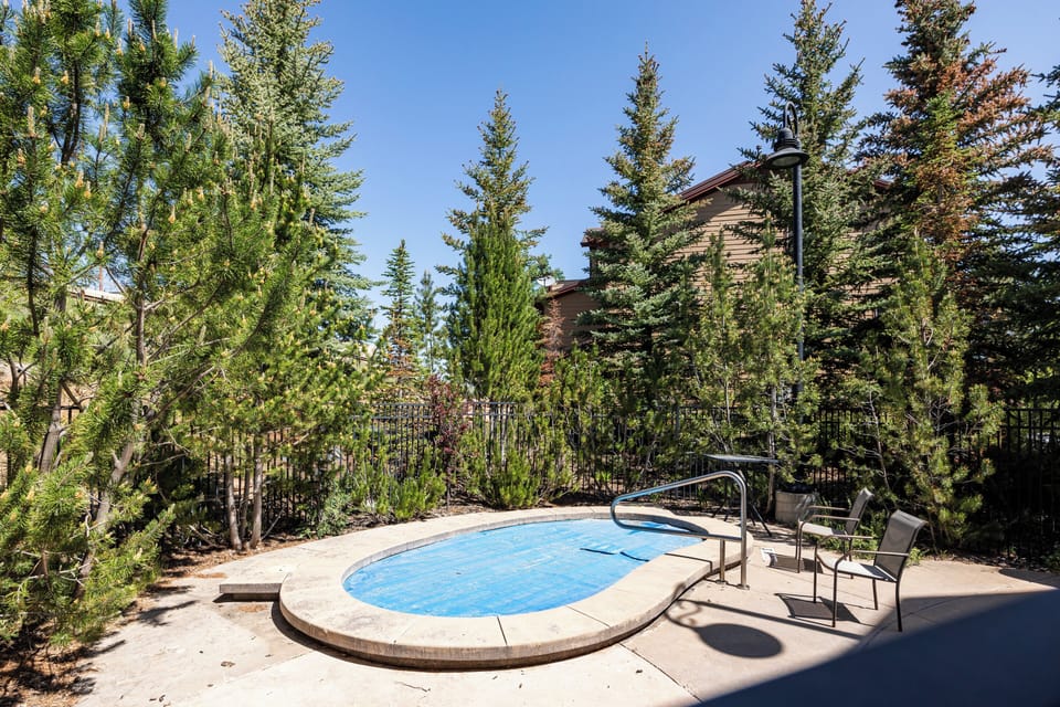 - Outdoor hot tub surrounded by tall pine trees  
- Private seating area for relaxation after a long day  
- Peaceful mountain setting perfect for evening unwinds