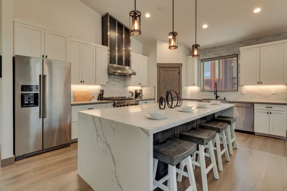 Kitchen with an island, bar stools, and stainless steel appliances