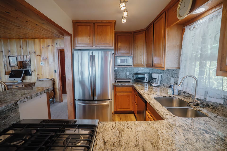 Compact yet fully equipped kitchen featuring stainless steel appliances and all essential cookware