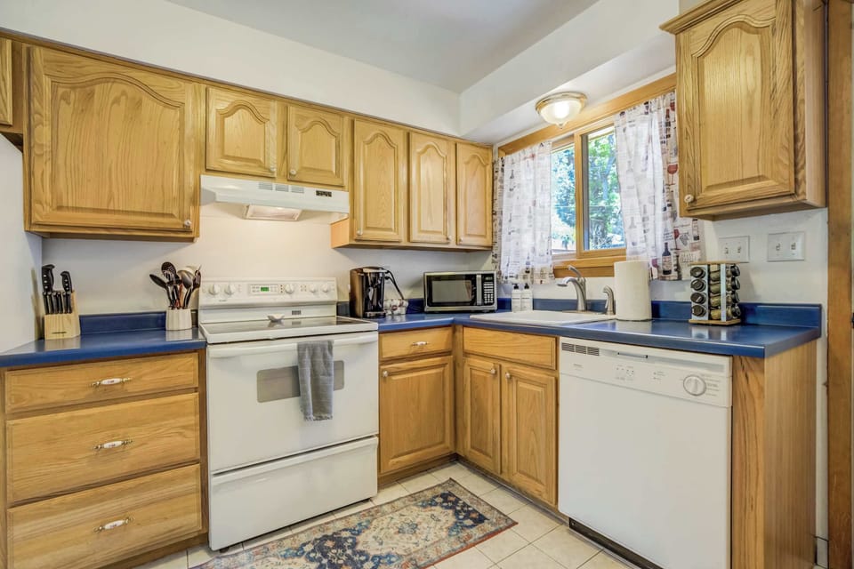 The kitchen is fully stocked for all your cooking needs, with ample cabinetry, modern appliances, and extra touches like a spice rack and coffee maker to make meals easy and enjoyable.







