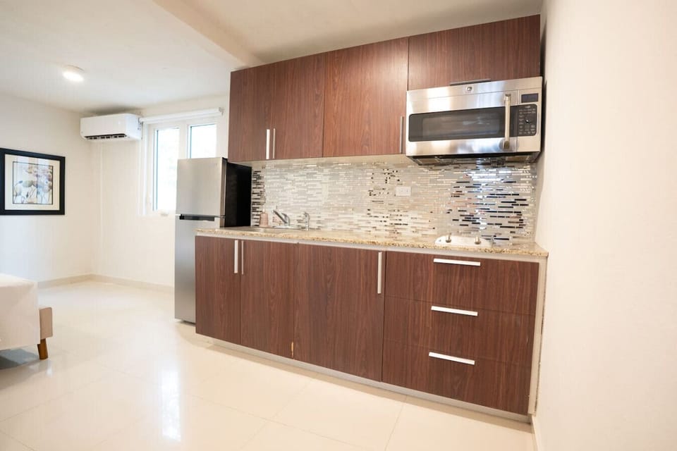 A closer look at the kitchen`s ample counter space, stylish backsplash, and modern appliances.