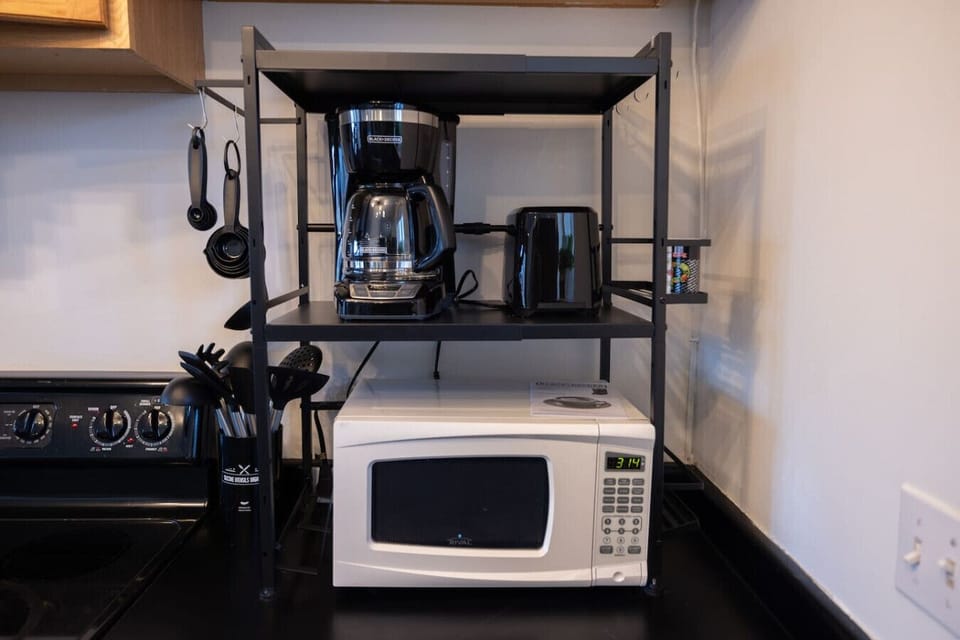 Compact kitchenette with microwave, coffee maker, and toaster