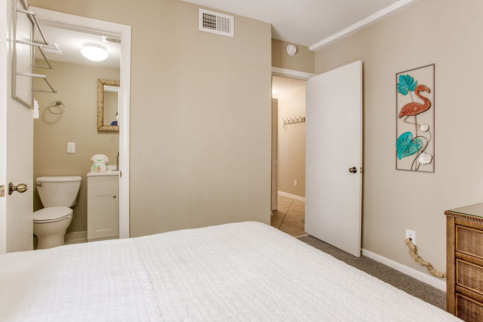 Guest bedroom with double and twin beds at Wind Drift Orange Beach
