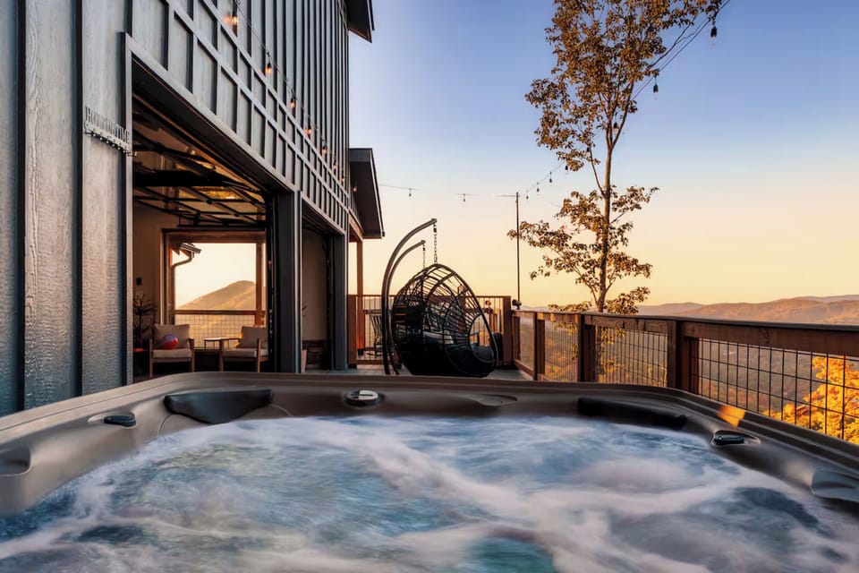 Relax in the outdoor hot tub while enjoying mountain views at sunset.