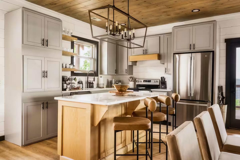 Modern kitchen with a large island and leather bar stools for casual dining.