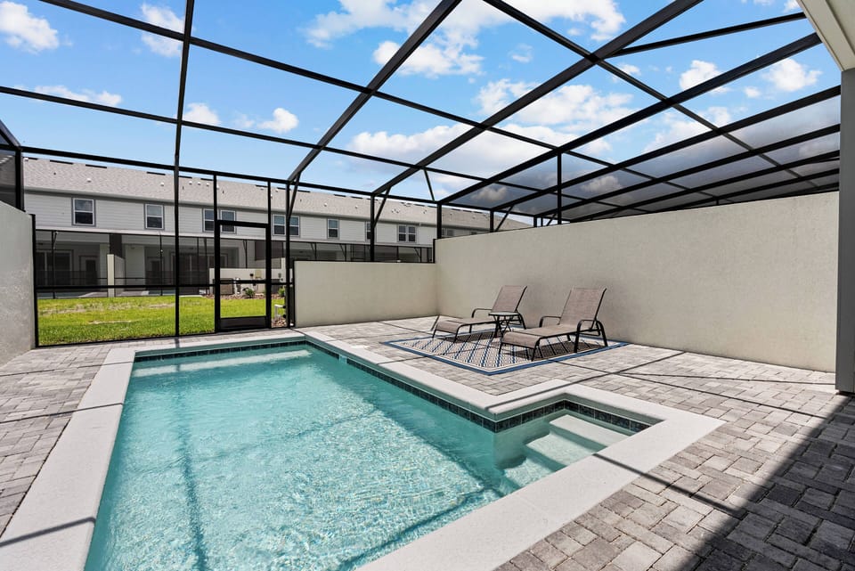 Step outside to your private oasis with a sparkling pool, sleek pavers, and cozy lounge chairs. Enjoy fresh air in the screened enclosure, inviting you to relax and unwind under the beautiful blue sky.