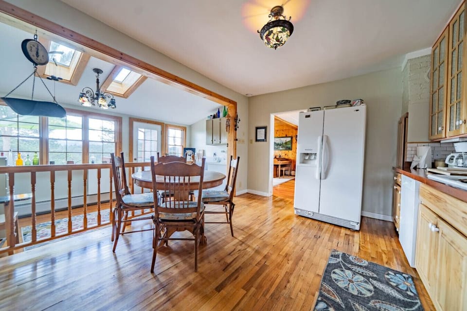 Another view of the second dining area showing the kitchen. Through the sunroom door as a patio with a grill.