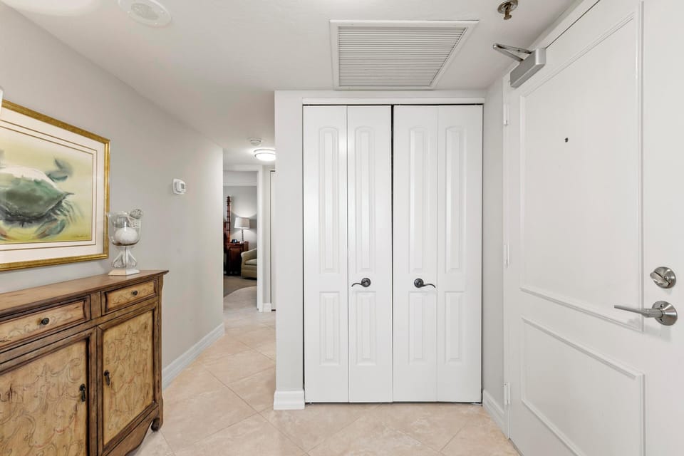 Entranceway storage closet and hallway to bedrooms and bathrooms