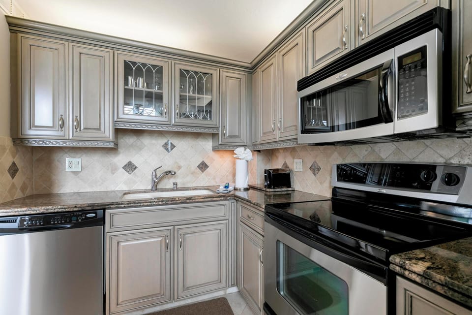 Kitchen with stainless microwave, range, and dishwasher