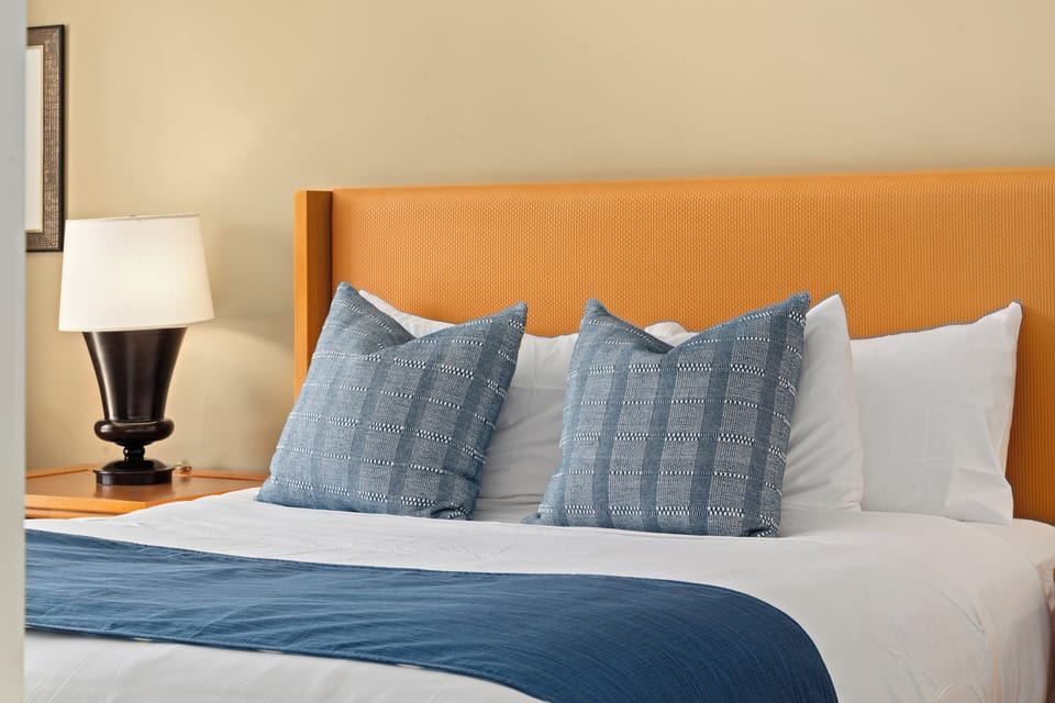 Layered pillows and warm lighting add comfort and charm to the restful suite at Honua Kai Konea 230.