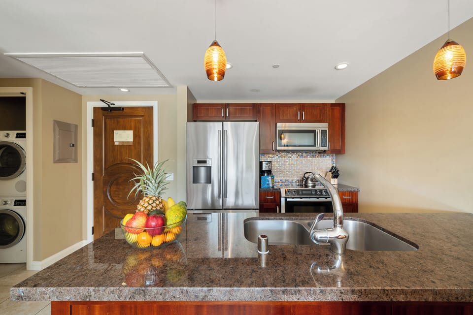 This fully stocked kitchen at Honua Kai Konea 230 features granite countertops and stainless appliances for seamless meal prep.
