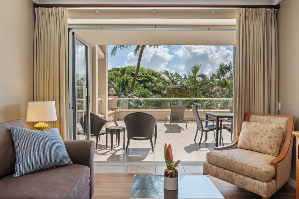 This fully stocked kitchen at Honua Kai Konea 230 features granite counters, stainless steel appliances, and island seating.