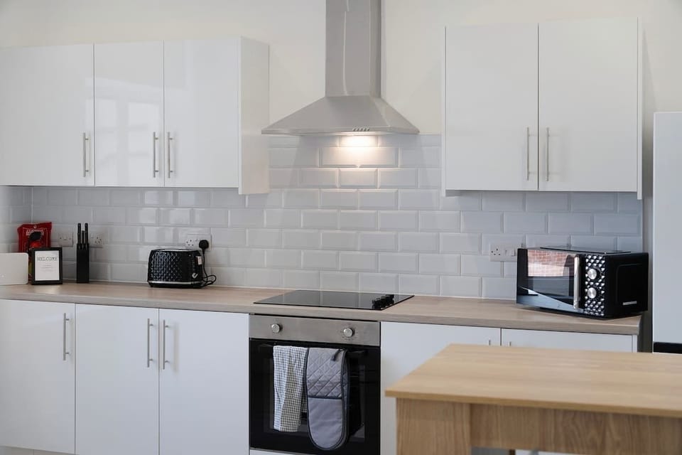 Kitchen fitted with essential appliances such as hob, oven, microwave, fridge/freezer, and fully supplied with cooking tools and dining ware. Includes washing machine for added convenience.
