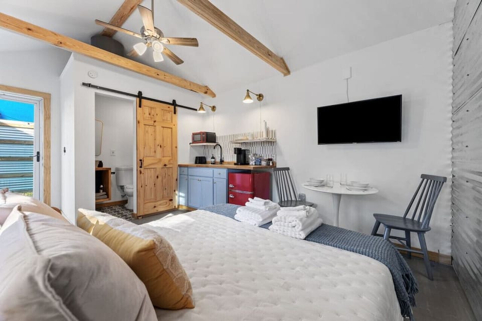 Compact guest space with bed, kitchen, and seating.
