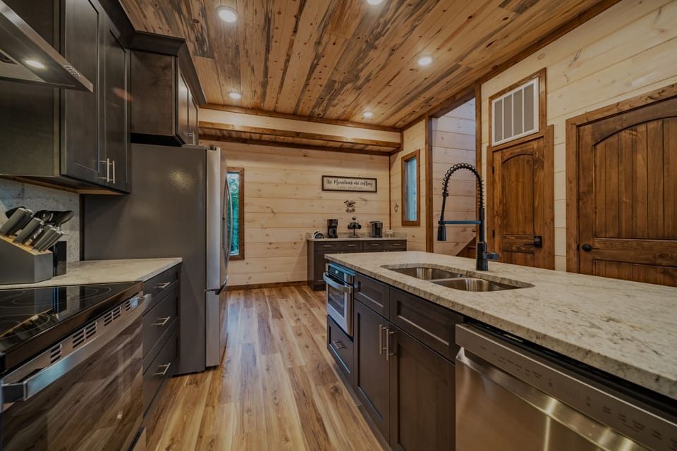 Kitchen with stainless steel appliances and cooking supplies. 