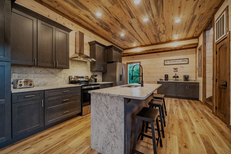 Kitchen with stainless steel appliances and cooking supplies. 
