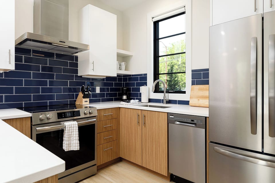 Enjoy the sleek design and natural light in this contemporary kitchen, perfect for home-cooked meals.