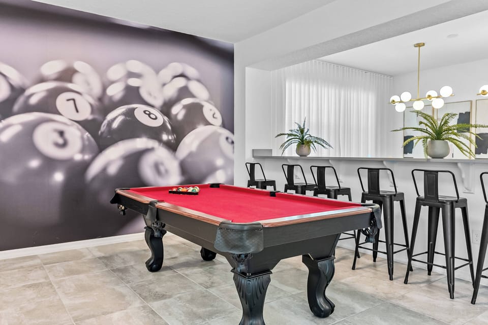 Experience leisure at its finest with a stylish billiard table and a vibrant pool ball wall. The chic bar, complete with sleek black stools and modern lighting, sets the ideal scene for memorable gatherings and enjoyable evenings.