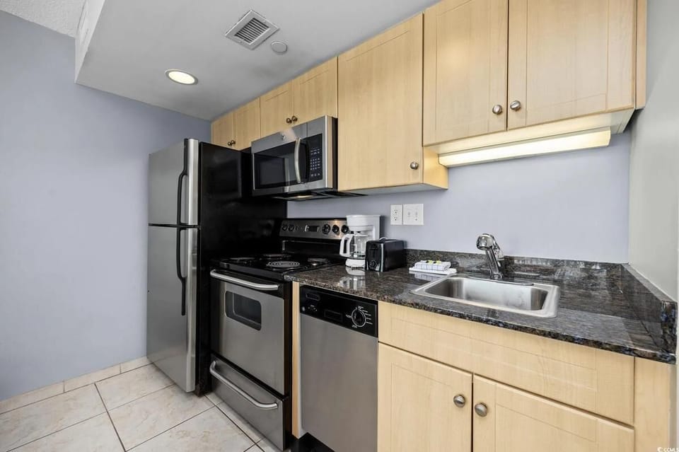 Fully equipped kitchen featuring wood cabinetry and spacious layout