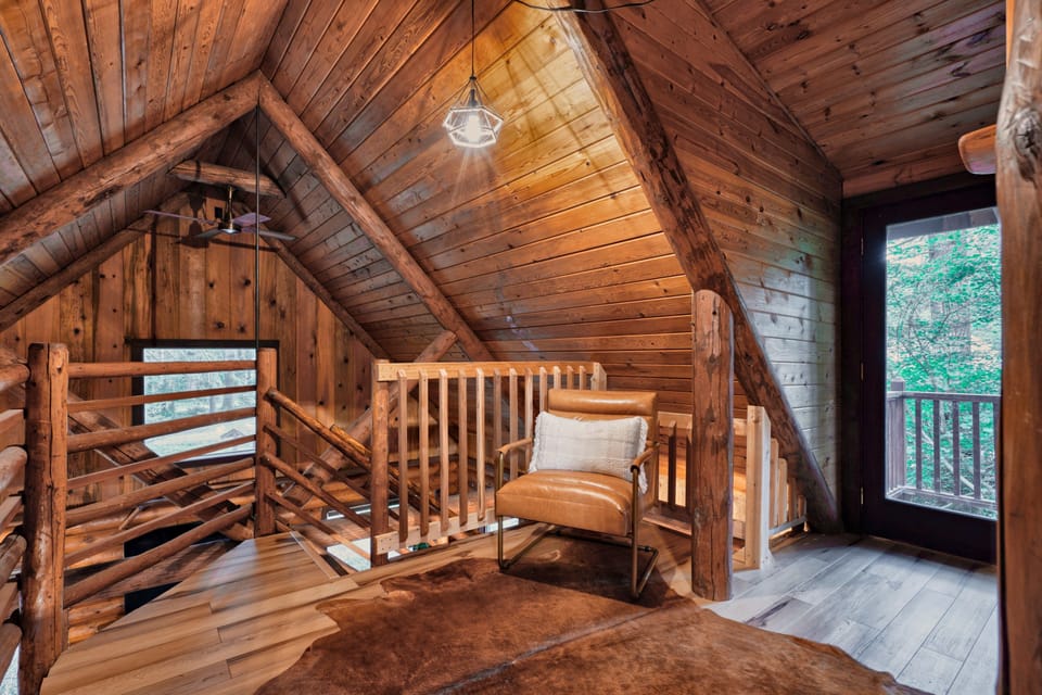 Upstairs loft landing with a leather chair beside the railing.