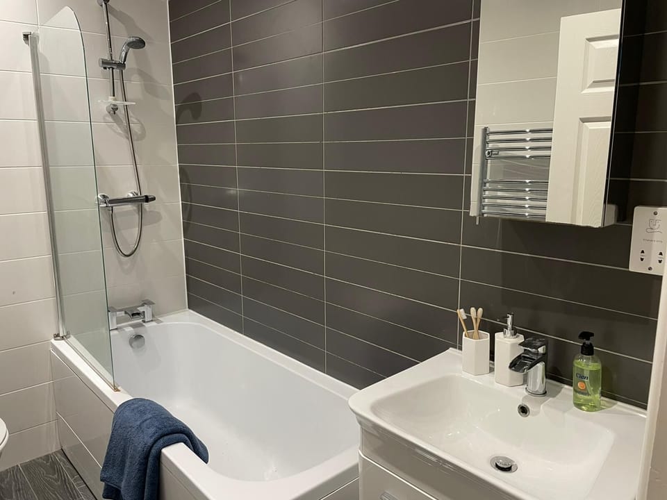 The modern bathroom is equipped with a toilet, sink, and an electric shower over the bath, giving you the flexibility of a quick refresh or a relaxing soak after a day exploring Liverpool.