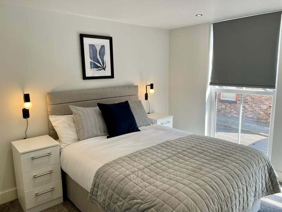 Bedroom 2 is a bright and comfortable space featuring a double bed, ample wardrobe storage, and a chest of drawers. Large windows allow plenty of natural light to fill the room, creating a relaxing environment to unwind after a busy day.