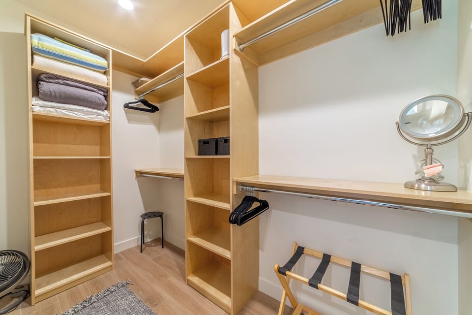Primary walk-in closet equipped with vast storage shelves and hanging space.